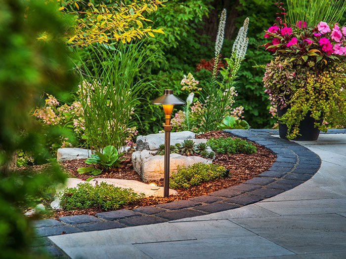 This immersive outdoor transformation blends refined stonework, biodiversity, and thoughtful zones of relaxation