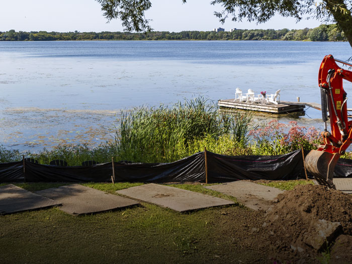 A heritage-approved landscape featuring natural stone, custom carpentry, and smart elevation work along Kingston’s scenic shoreline.